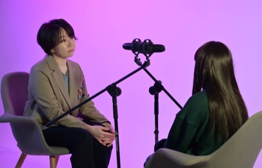 a-long-haired-woman-and-an-interviewer-on-a-pink-background